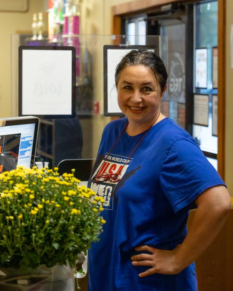 A smiling TEG staff member at the front desk