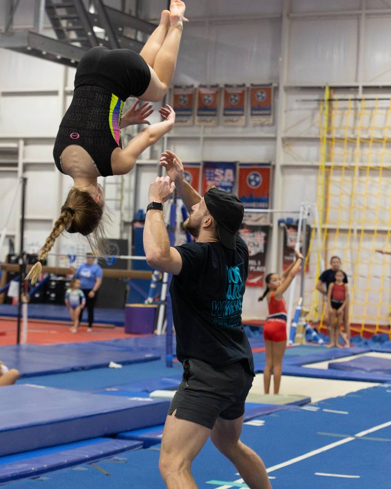 A TEG coach spotting an athlete's flip